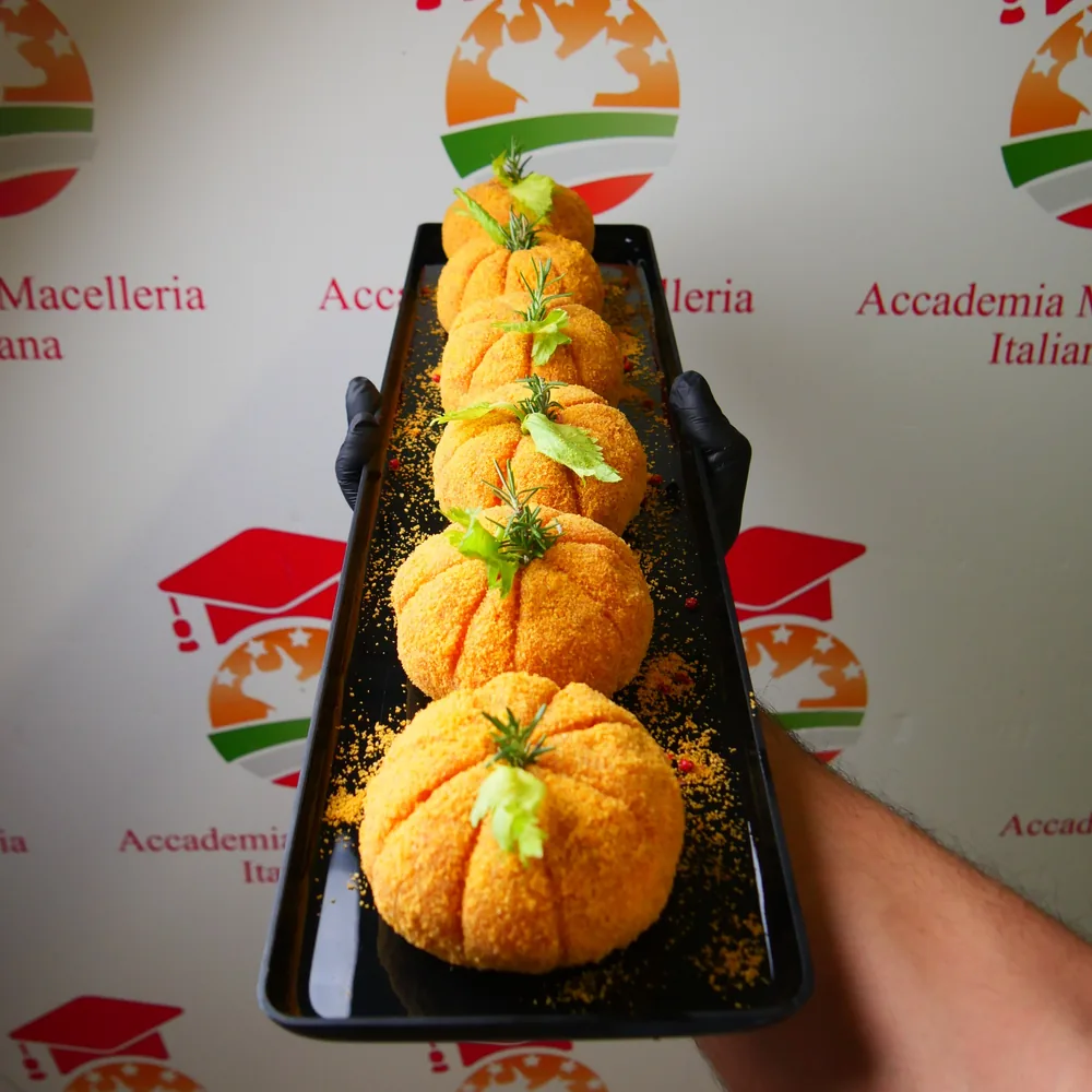 Zucche ripiene su un vassoio, davanti al marchio di Accademia Macelleria Italiana
