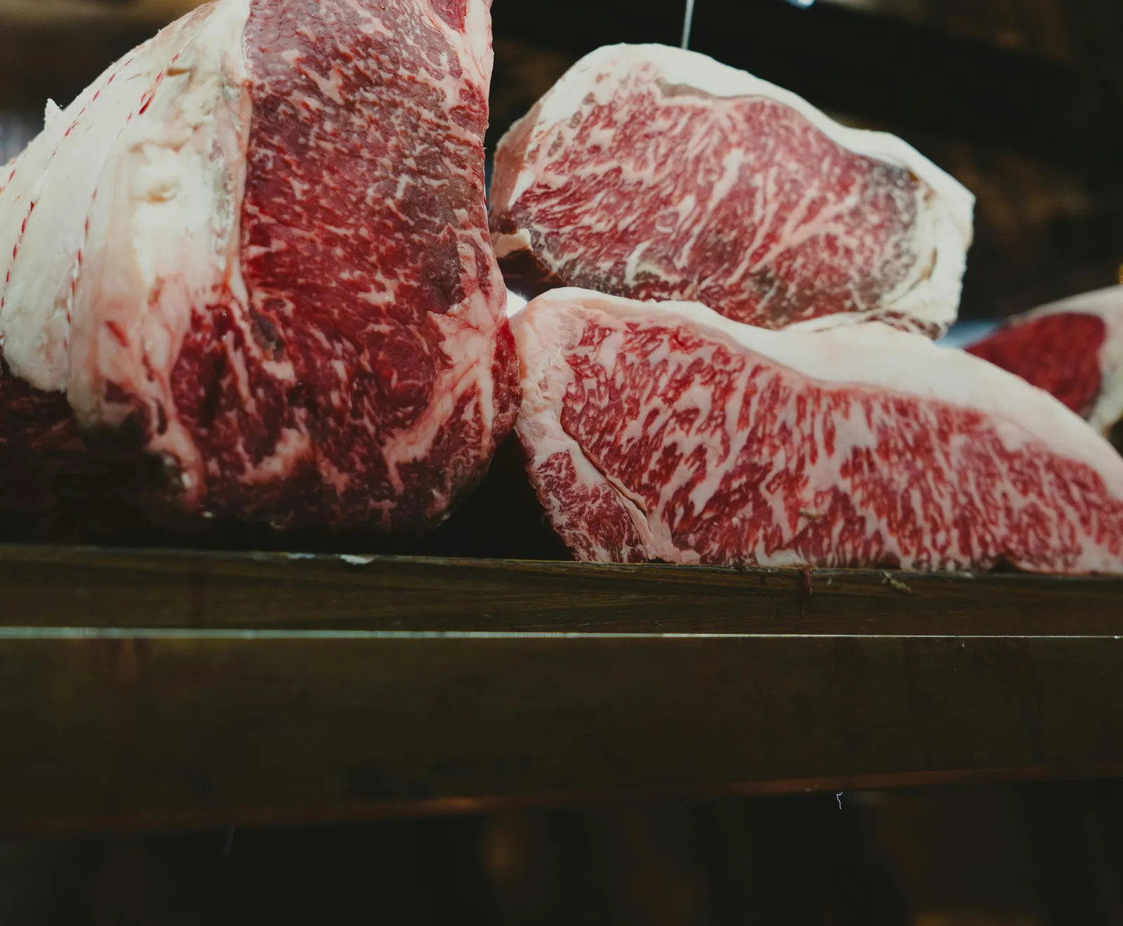 Tagli di carne con marezzatura ricca esposti al banco della macelleria