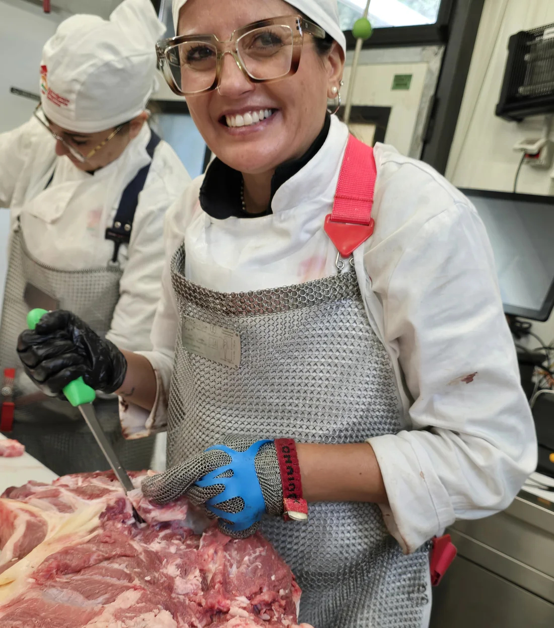 Allieva del corso di macelleria dell'Accademia Macelleria Italiana mentre seziona un quarto di carne in laboratorio